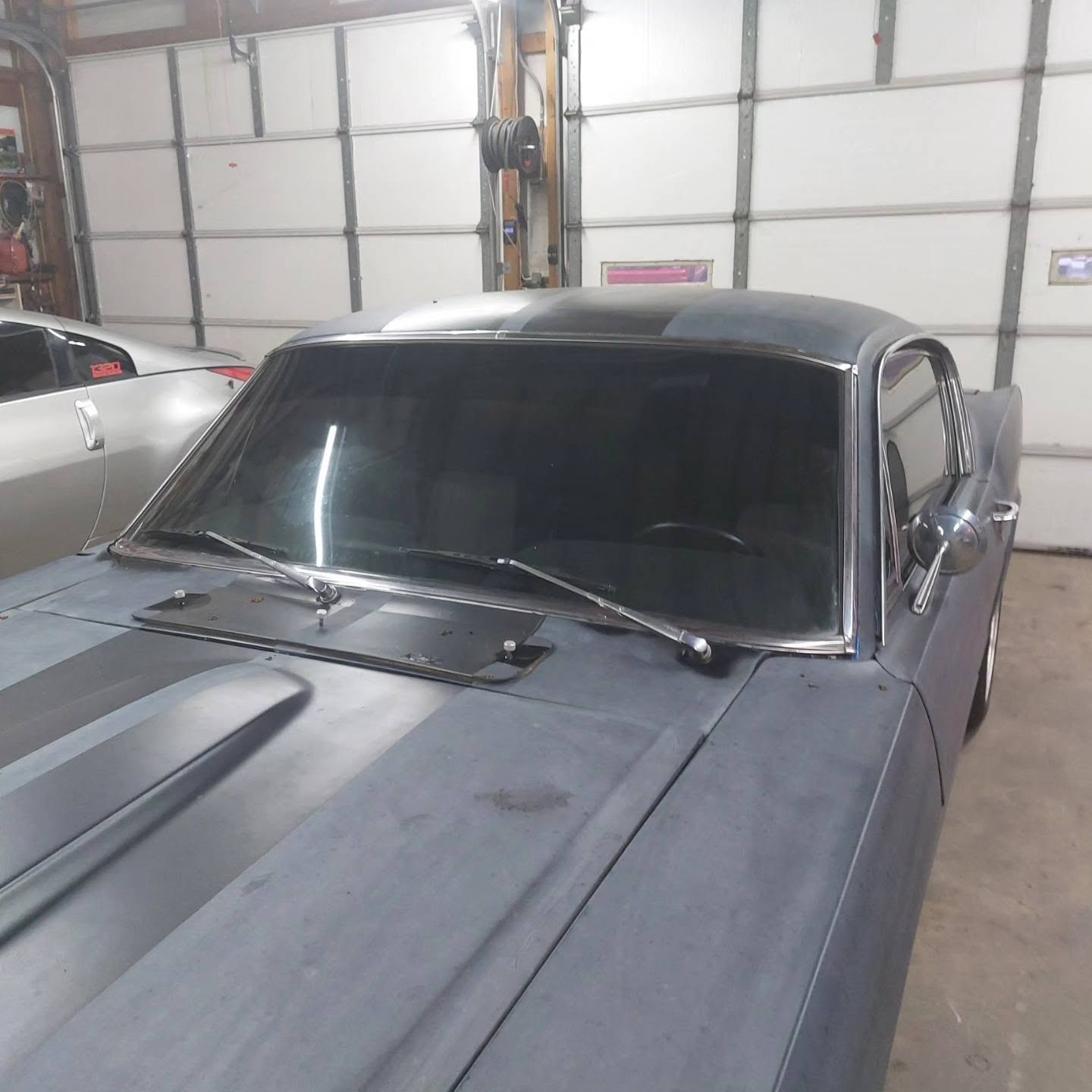 Classic car with darkened windows in garage workshop setting