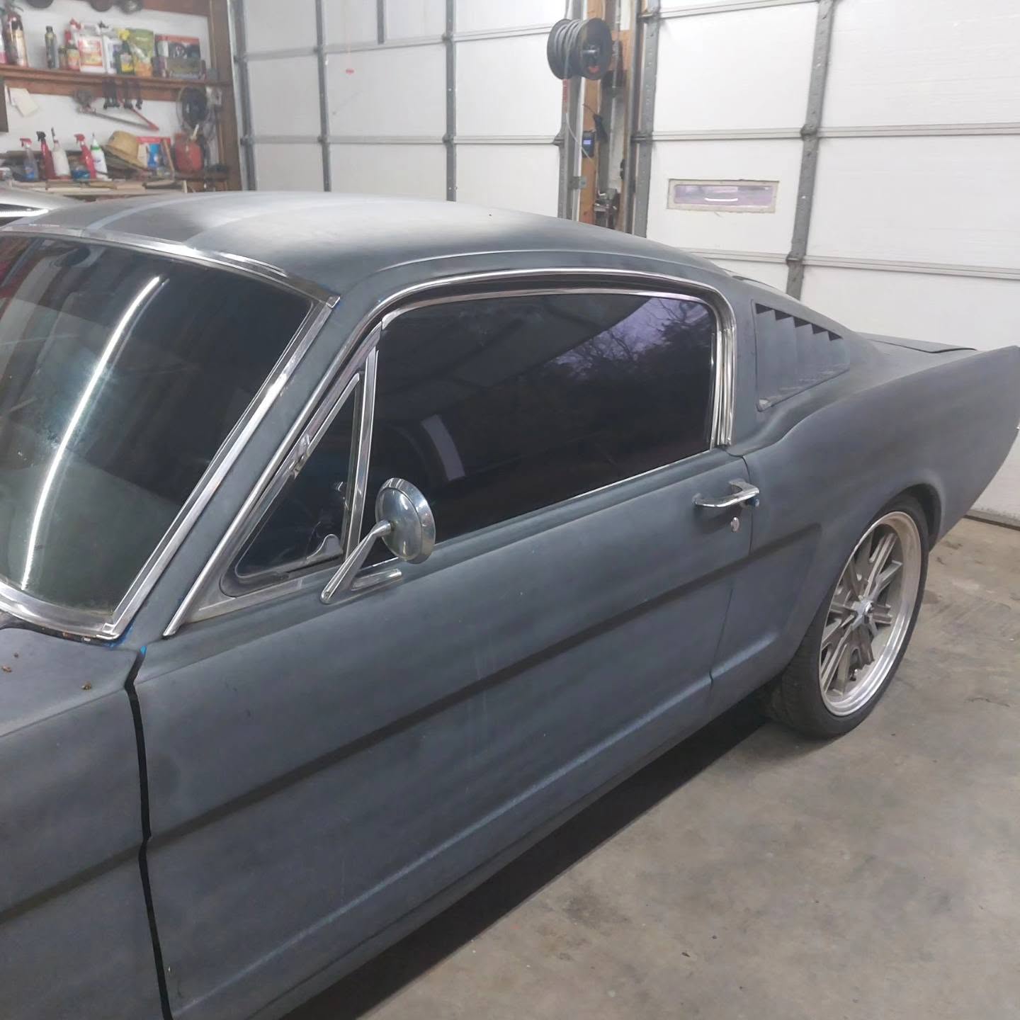 Classic blue coupe in garage with chrome trim and modern wheels